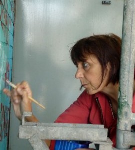 Malerin der FrauenFreiluftGalerie bei der Arbeit am 13. Wandgemälde "Immer an der Wand lang - Frauengemälde am Hafen"